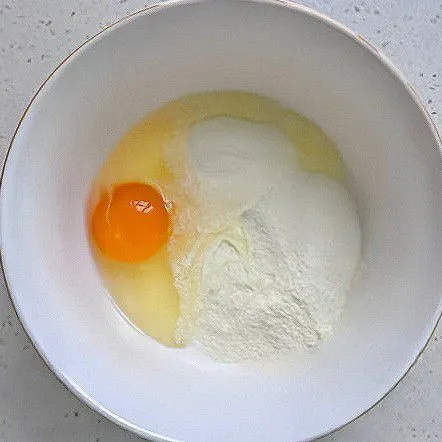 Campurkan 30 gr tepung beras, 1 butir telur ayam, dan 10 gr susu bubuk ke dalam mangkuk.