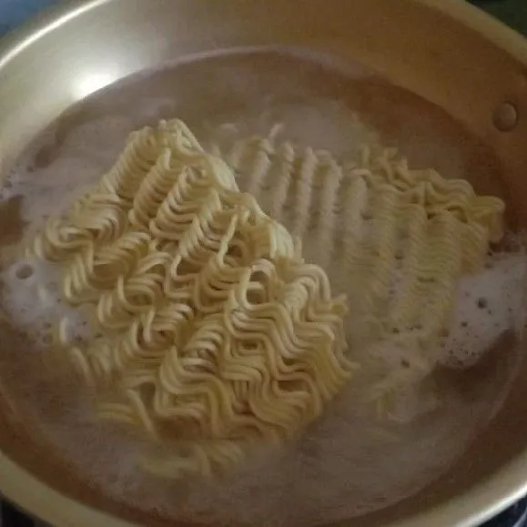 Rebus mie telur instan hingga matang, jangan terlalu lembek. Angkat dan tiriskan.