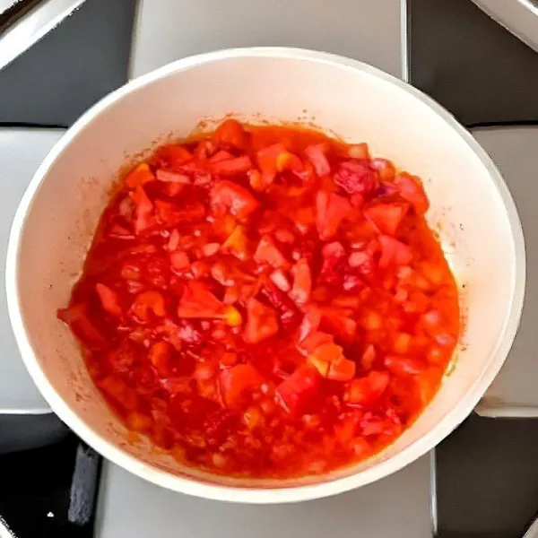 Dalam wajan lain, tumis 30 gr bawang bombay cincang hingga harum. Tambahkan 150 gr tomat dadu, aduk hingga layu dan berair