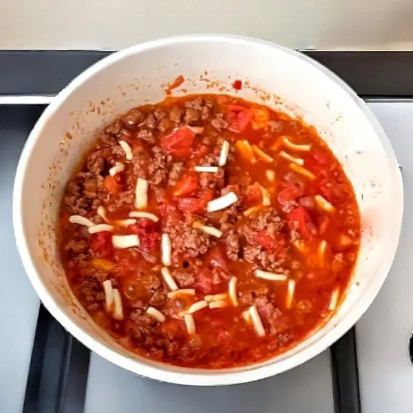 Taburkan 20 gr keju mozzarella, aduk hingga meleleh dan merata dalam saus