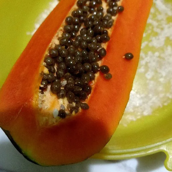 Buang biji dan kupas kulit buah pepaya.