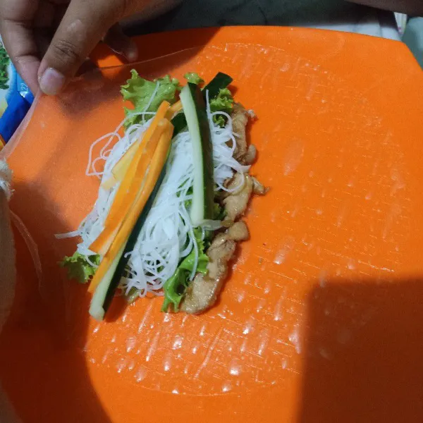 Oseng ayam di atas pan dengan sedikit mentega, lalu oseng ayam fillet dan beri bumbu saus tiram dan garam. Oseng sebentar sampai berubah warna dan angkat, lalu masukkan ke susunan vietnam spring roll.