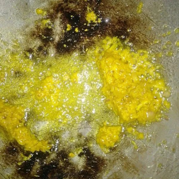 Panaskan minyak, lalu tumis kunyit, kemiri, bawang putih, dan bawang merah sebagai bumbu halus sampai wangi.