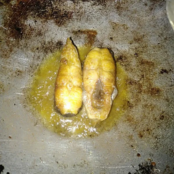 Bersihkan ikan, lalu marinasi dengan bumbu ikan. Goreng ikan patin sampai matang dan berubah warna kecokelatan.