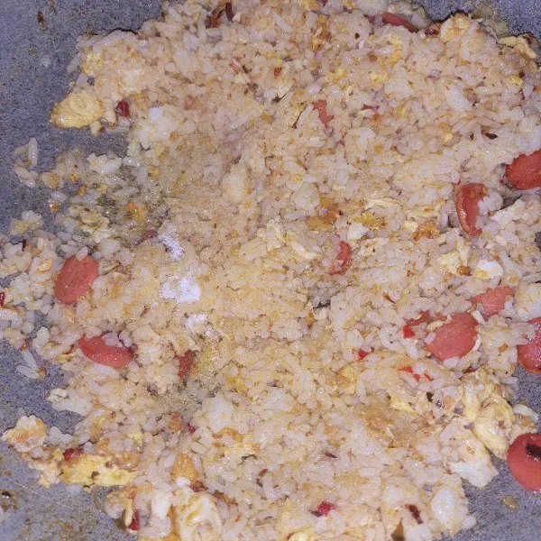 Tambahkan garam dan kaldu bubuk. Bolak-balik sampai bumbu merata dan nasi tidak gosong. Jika sudah pas, matikan api. Sajikan dengan pelengkap kol iris dan bawang goreng.