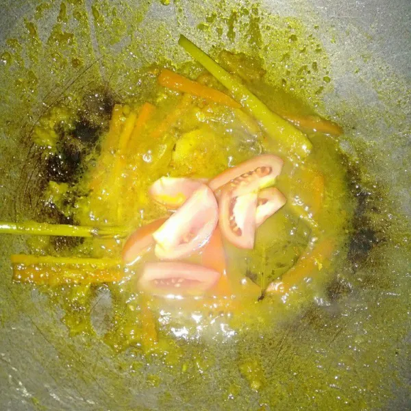 Masukkan wortel, lalu tuangkan air secukupnya dan irisan tomat.