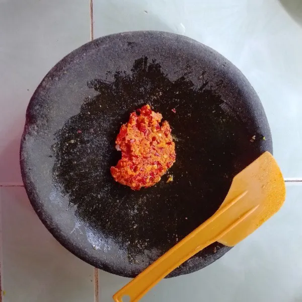 Haluskan bawang putih, bawang merah, kemiri, ketumbar, kunyit, cabe merah keriting, dan garam secukupnya menggunakan ulekan.