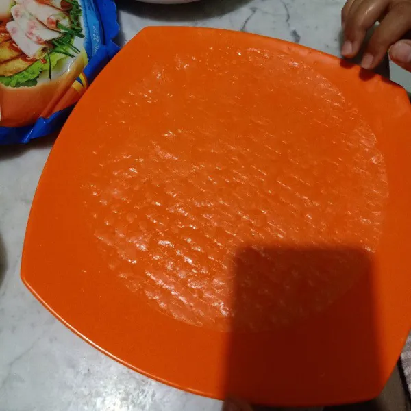 Siapkan wadah, lalu beri sedikit air dan celupkan rice paper ke dalam air. Angkat dan sisihkan ke wadah piring.