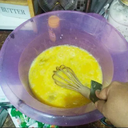 Masukkan 3 butir telur dan gula pasir, lalu aduk rata hingga gulanya larut menggunakan whisk.