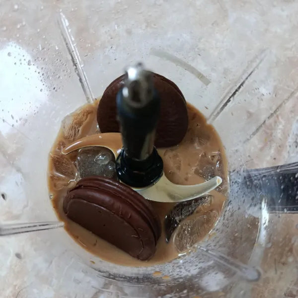 Masukkan whipped cream bubuk, kue rasa cokelat, perisa vanilla, dan susu kental manis.