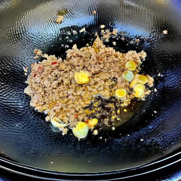 Campurkan daging sapi cincang dengan saus kacang fermentasi, tepung maizena, dan air. Aduk rata, lalu diamkan selama 10 menit. Panaskan minyak dan tumis daging sapi hingga berubah warna.