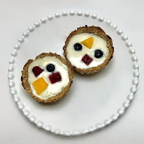 Keluarkan cup dari oven, biarkan dingin sebentar. Tuangkan plain yogurt ke dalam cup, lalu hiasi dengan buah segar seperti potongan mangga, naga merah, dan blueberry.