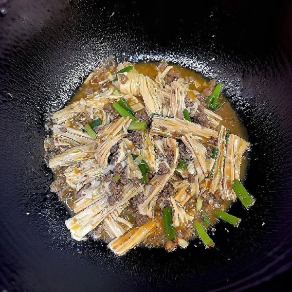 Masukkan daun bawang, lanjut masak hingga kuah mengental sedikit.