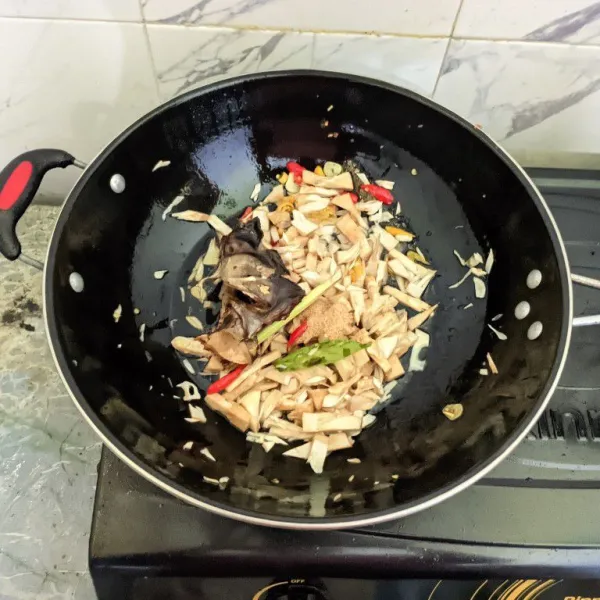 Masukkan kepala ikan asap yang telah digoreng, lalu tambahkan kaldu bubuk. Tuang air. Masak hingga air menyusut dan bumbu meresap.