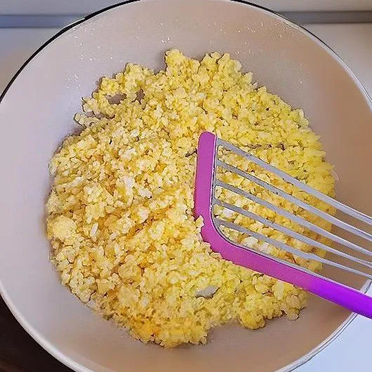 Panaskan minyak di wajan, lalu masukkan nasi yang sudah dicampur dengan kuning telur dan tumis hingga butiran nasi terpisah serta berwarna keemasan. Angkat dan sisihkan.