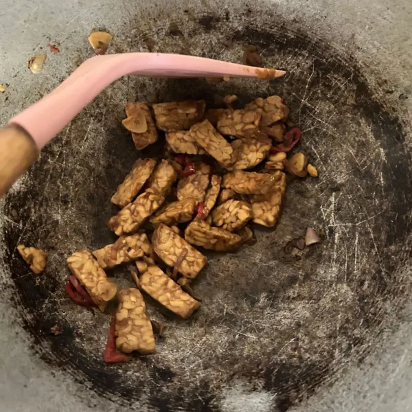 Masukkan tempe yang telah dipotong kotak-kotak, lalu oseng sebentar dan tambahkan kecap manis, saus tiram, garam, dan penyedap rasa. Tuangkan sedikit air, lalu aduk hingga bumbu meresap sempurna.