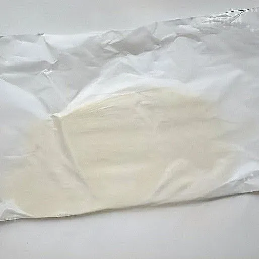 Letakkan adonan di antara dua lembar kertas minyak, lalu gilas hingga pipih.