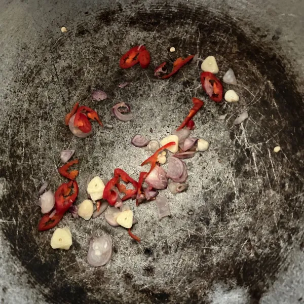 Iris tipis bawang merah, bawang putih, dan cabe rawit, lalu tumis hingga harum.