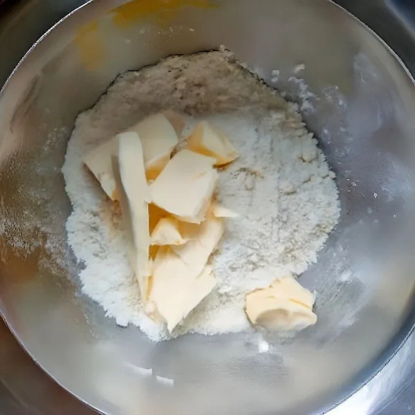 Campurkan tepung terigu rendah protein, mentega dingin, dan gula pasir. Aduk dengan tangan hingga berbutir seperti pasir kasar, lalu simpan crumble ke dalam kulkas.