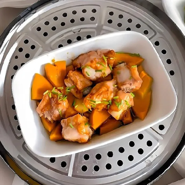 Kukus dengan api sedang selama 30 menit hingga iga matang empuk dan labu lembut. Taburkan daun bawang cincang di atasnya.