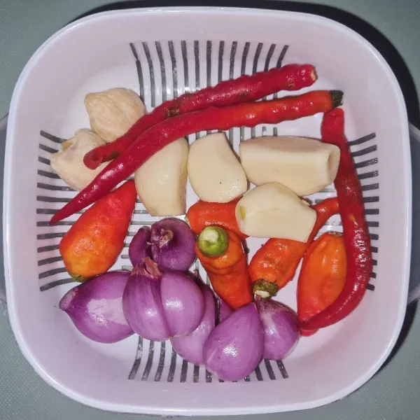 Haluskan bawang merah, bawang putih, cabe rawit, cabe keriting, dan kemiri.