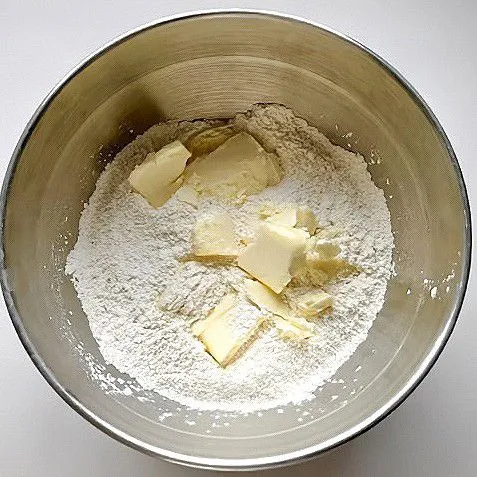 Campurkan 200 gr tepung, 20 gr gula, 1 gr garam, dan 5 gr baking powder. Masukkan 60 gr mentega dingin, aduk hingga berbutir pasir