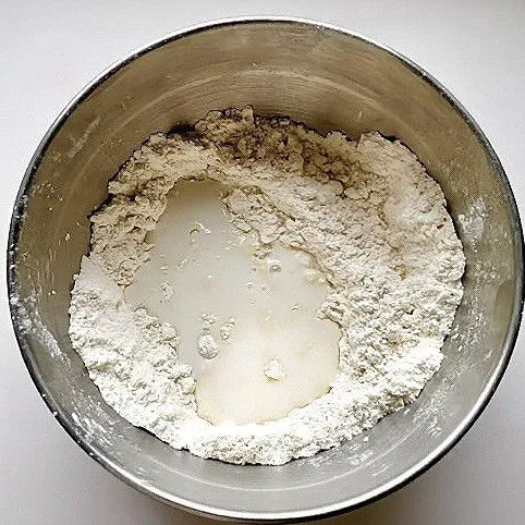 Tuang 100 ml susu cair, aduk hingga hampir kalis