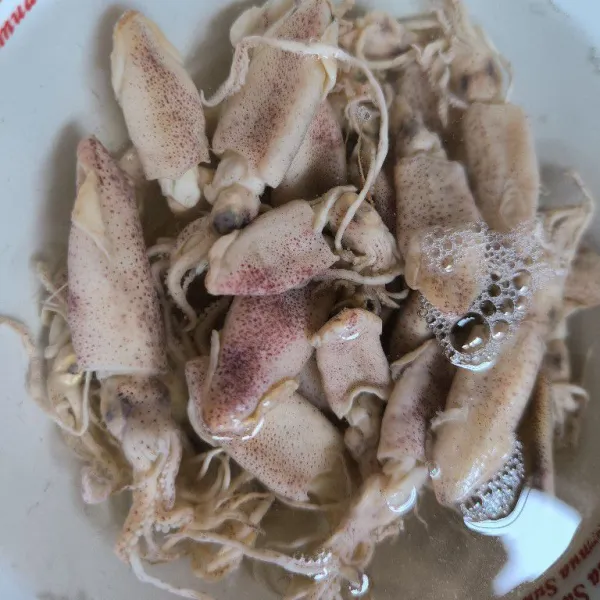 Rendam cumi asin dengan air panas selama 10 menit. Potong-potong, kemudian cuci bersih.