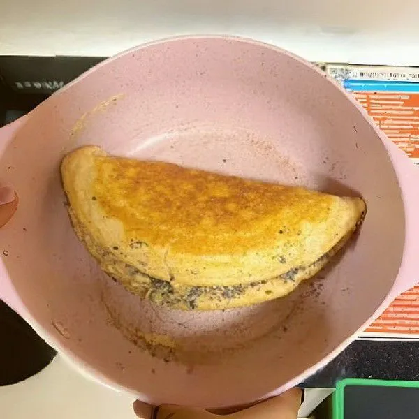 Lipat pancake menjadi setengah lingkaran. Masak kedua sisi selama 3 menit hingga matang dan berwarna keemasan