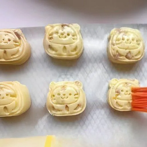 Bagi adonan menjadi bulatan masing-masing ±25 gr. Olesi cetakan dengan 1 sdm minyak, lalu tekan adonan ke dalam cetakan hingga berbentuk karakter lucu