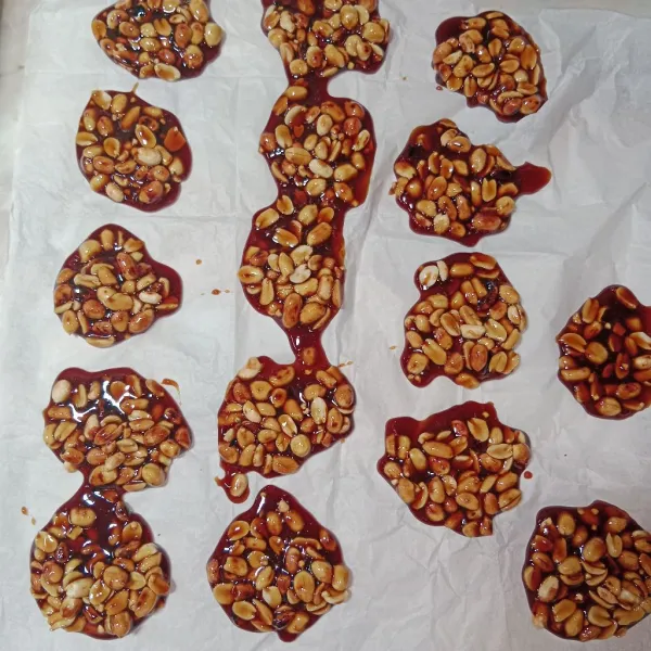 Tuangkan sesendok kacang di atas kertas baking paper, lalu diamkan sampai gula kacang mengeras.