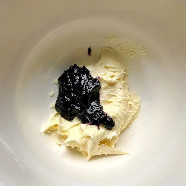 Tambahkan 30 gr saus blueberry, aduk rata. Masukkan ke piping bag, simpan di kulkas