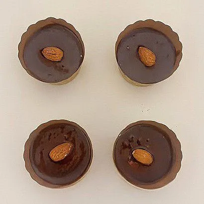 Tutup kembali dengan sisa adonan cokelat, lalu beri 1 buah almond utuh di atasnya