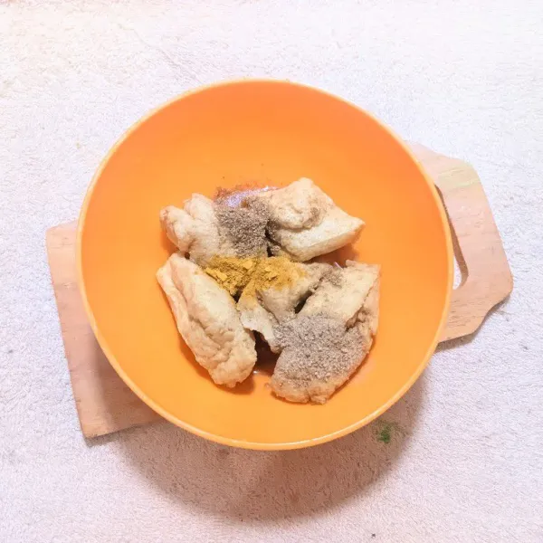 Marinasi tahu kulit dengan kunyit bubuk, ketumbar bubuk, kaldu bubuk, dan air. Diamkan selama 5 menit.