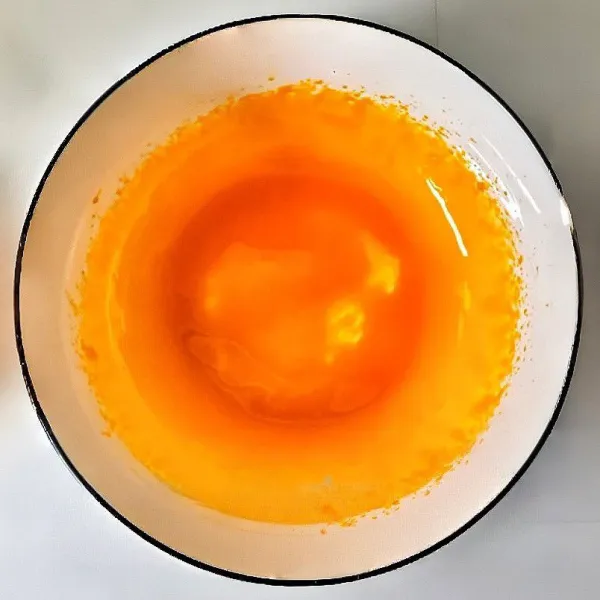 Masukkan kuning telur ke dalam wadah, tambahkan 1 sdt garam, kocok menggunakan mixer hingga berwarna lebih pucat dan berbusa. Lelehkan 20 gr mentega dengan cara ditim, tuang ke dalam adonan kuning telur. Kocok rata