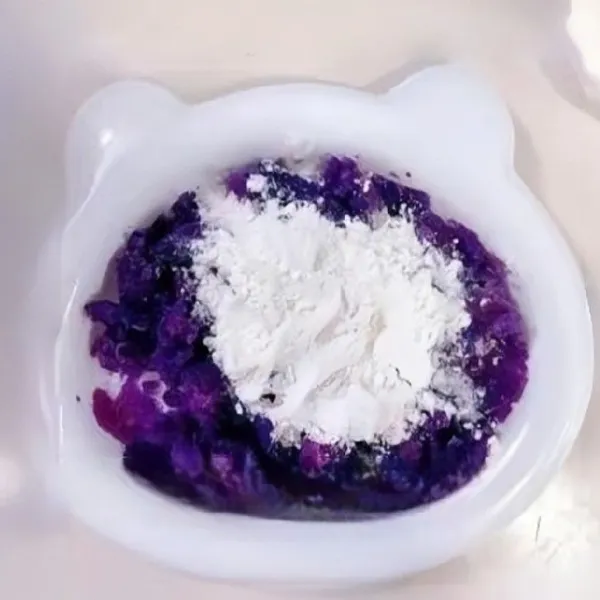 Tambahkan 20 gr tepung terigu ke dalam ubi ungu halus, aduk hingga rata dan membentuk adonan lembut