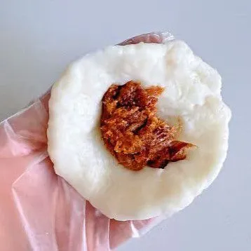 Bagi adonan menjadi beberapa bagian kecil seberat 40 gr per butir. Pipihkan satu bulatan adonan, lalu beri isian 15 gr pasta kacang merah di tengahnya. Tutup rapat bagian ujungnya, lalu tekan perlahan hingga membentuk bulatan pipih