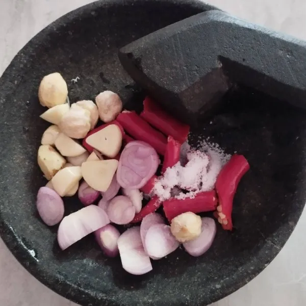 Haluskan kaldu bubuk, daun jeruk, gula pasir, garam, kencur, kemiri, cabe merah, cabe rawit, bawang merah, dan bawang putih sebagai bumbu halus.