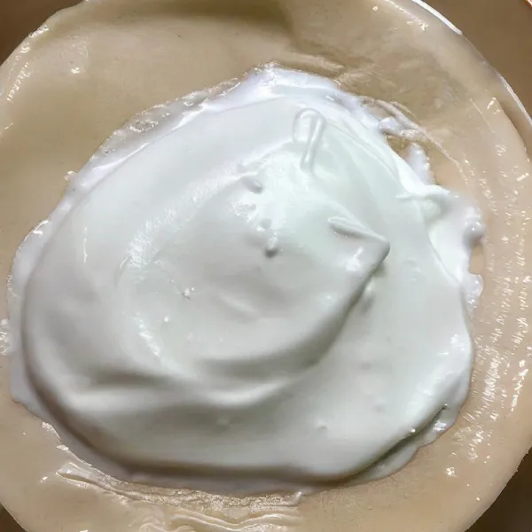 Letakkan selembar kertas roti di atas loyang, lalu tuang adonan meringue di atasnya dan ratakan sedikit membentuk bulatan tebal