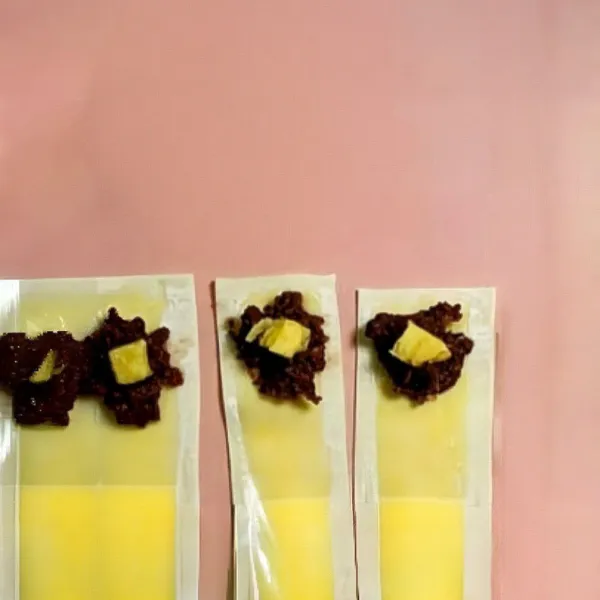 Tambahkan 1 sdt pasta kacang merah di tengah tiap kulit, lalu tambahkan ½ sdt (sekitar 5 ml) susu kental manis di atasnya