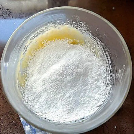 Ayak dan masukkan 50 gr tepung terigu protein rendah, lalu aduk hingga membentuk adonan lembut. Aduk hingga adonan rata dan kalis