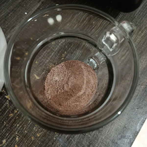 Masukkan cokelat bubuk ke dalam gelas saji.