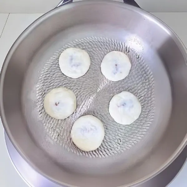 Oles sedikit minyak di permukaan wajan datar anti lengket, panaskan dengan api kecil. Masukkan adonan yang sudah dibentuk ke dalam wajan, panggang dengan api kecil