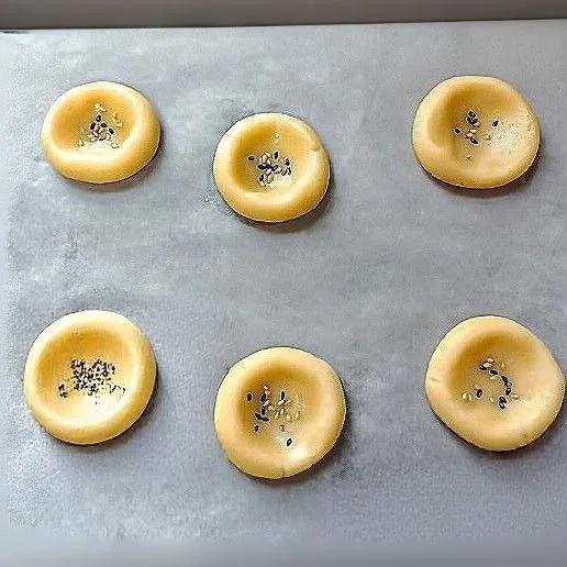 Taburi dengan sedikit biji wijen hitam dan putih di bagian atasnya. Panggang dalam oven suhu 170°C selama 20 menit hingga matang dan berwarna keemasan