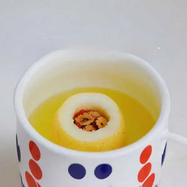 Masukkan ke dalam rongga pir masing-masing 10 gr goji berry, 10 gr kurma merah kering, 15 gr gula batu, lalu tuangkan 100 ml teh osmanthus hangat ke dalam setiap pir