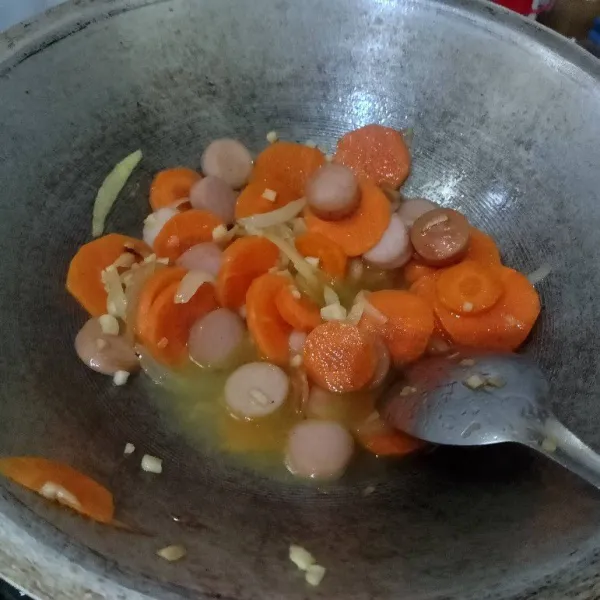 Masukkan irisan wortel dan sedikit air, masak 5 menit.