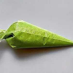 Untuk adonan putih, campurkan 15 gr tepung beras dan 10 gr air, aduk hingga rata dan kental. Masukkan adonan brokoli ke dalam piping bag, dan adonan putih ke dalam piping bag terpisah