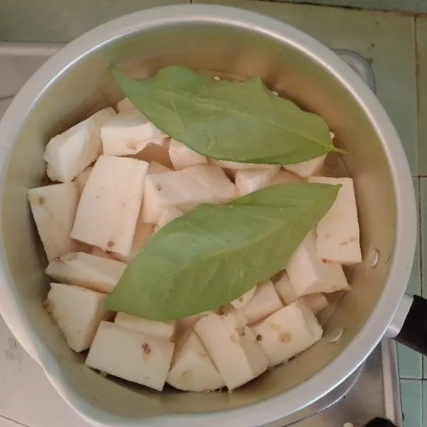 Masak ketela singkong dengan bumbu halus, lalu tambahkan daun salam dan tuangkan air secukupnya. Masak hingga setengah matang.