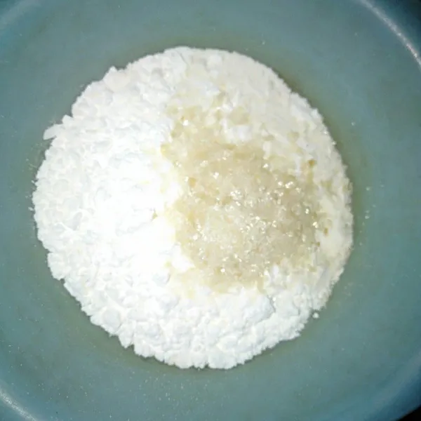 Campur tepung terigu dan gula pasir ke dalam wadah.