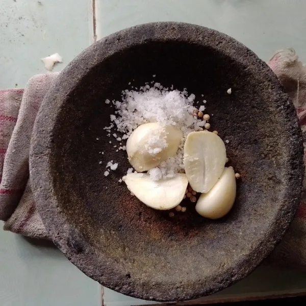 Campurkan bawang putih, ketumbar, dan garam secukupnya menggunakan ulekan hingga halus.
